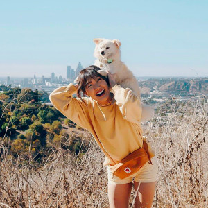 Young woman and her small white dog with a Whistle GPS.