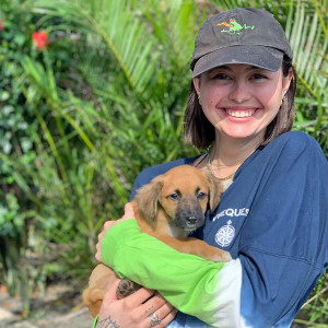 Woman volunteering and holding dog.