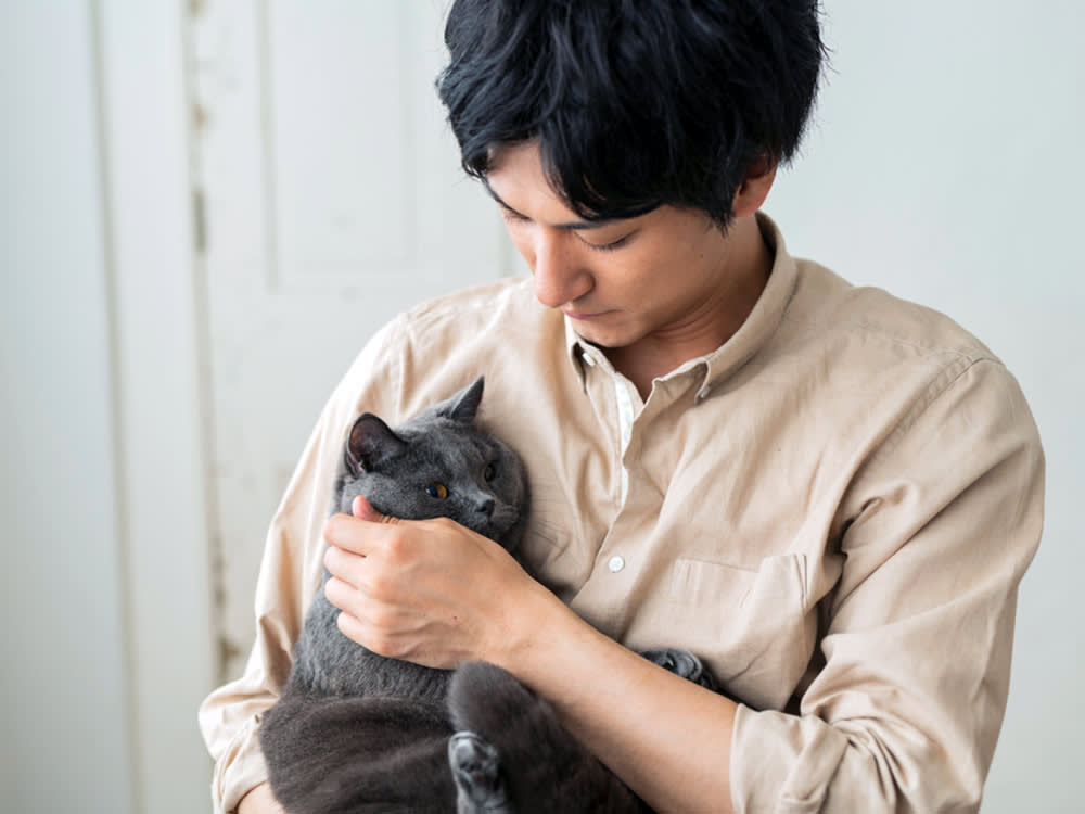 Man holding his large gray cat.