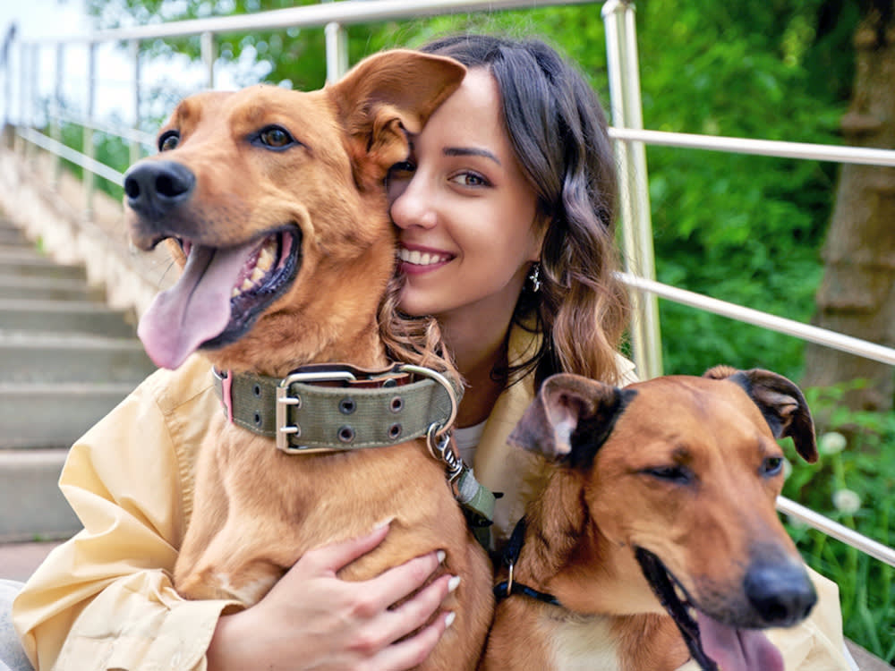 Woman with her two dogs outside.
