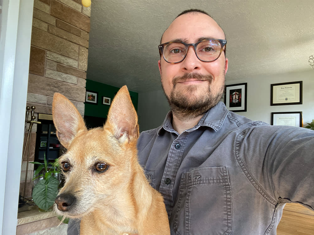 Dr. John Iovino smiling with a small dog.